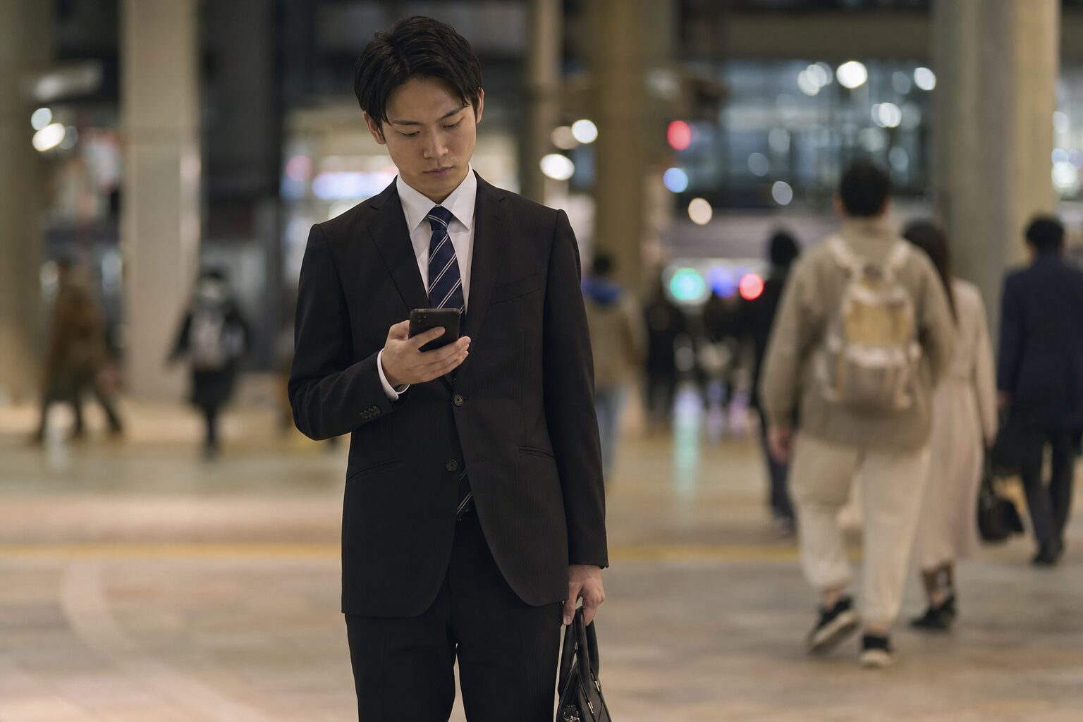 面接を終えた帰り道、辞退するかどうか迷いながらスマホを見つめる就活生のイメージ